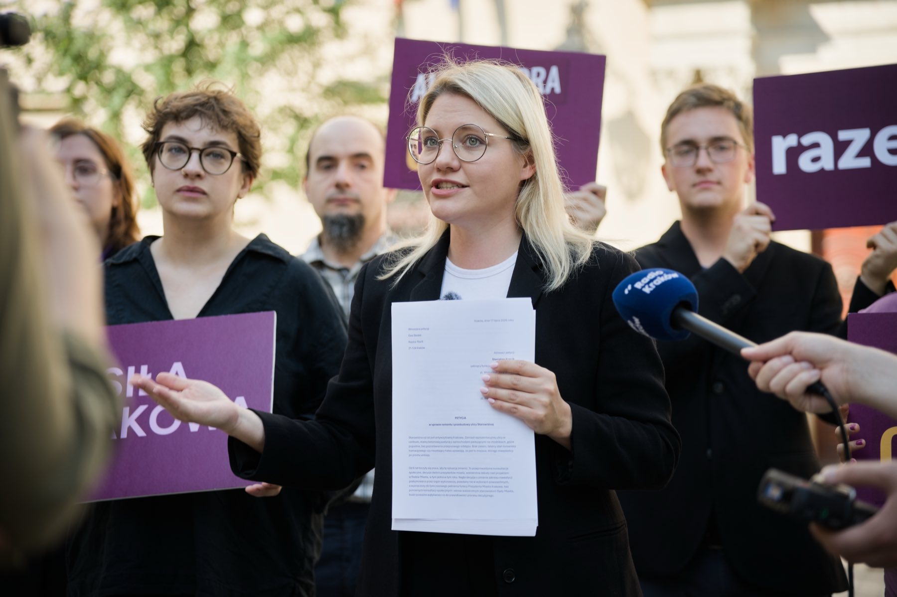 Aleksandra Owca przemawia podczas konferencji prasowej Partii Razem, trzymając w dłoniach petycję w sprawie przebudowy Starowiślnej